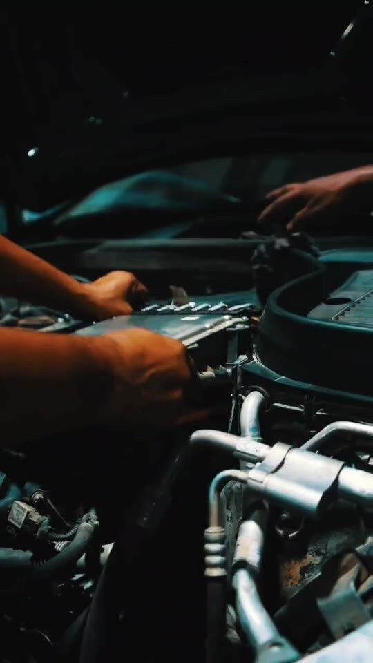Technician working carefully inside an engine bay